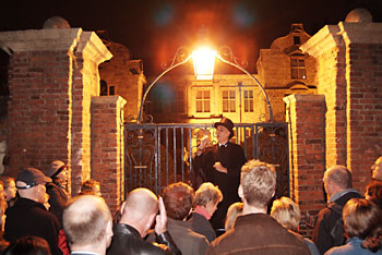 Ghost walk guide entetains tour.